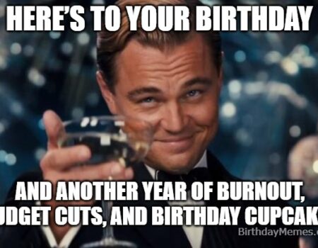 Leonardo DiCaprio giving a sarcastic toast with a paper cup in an office birthday setting.