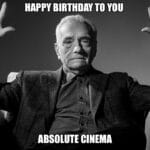 A serious man raises his hands with the text 'Happy Birthday To You Absolute Cinema.'