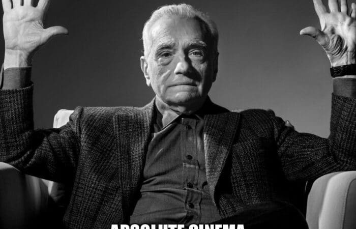 A serious man raises his hands with the text 'Happy Birthday To You Absolute Cinema.'