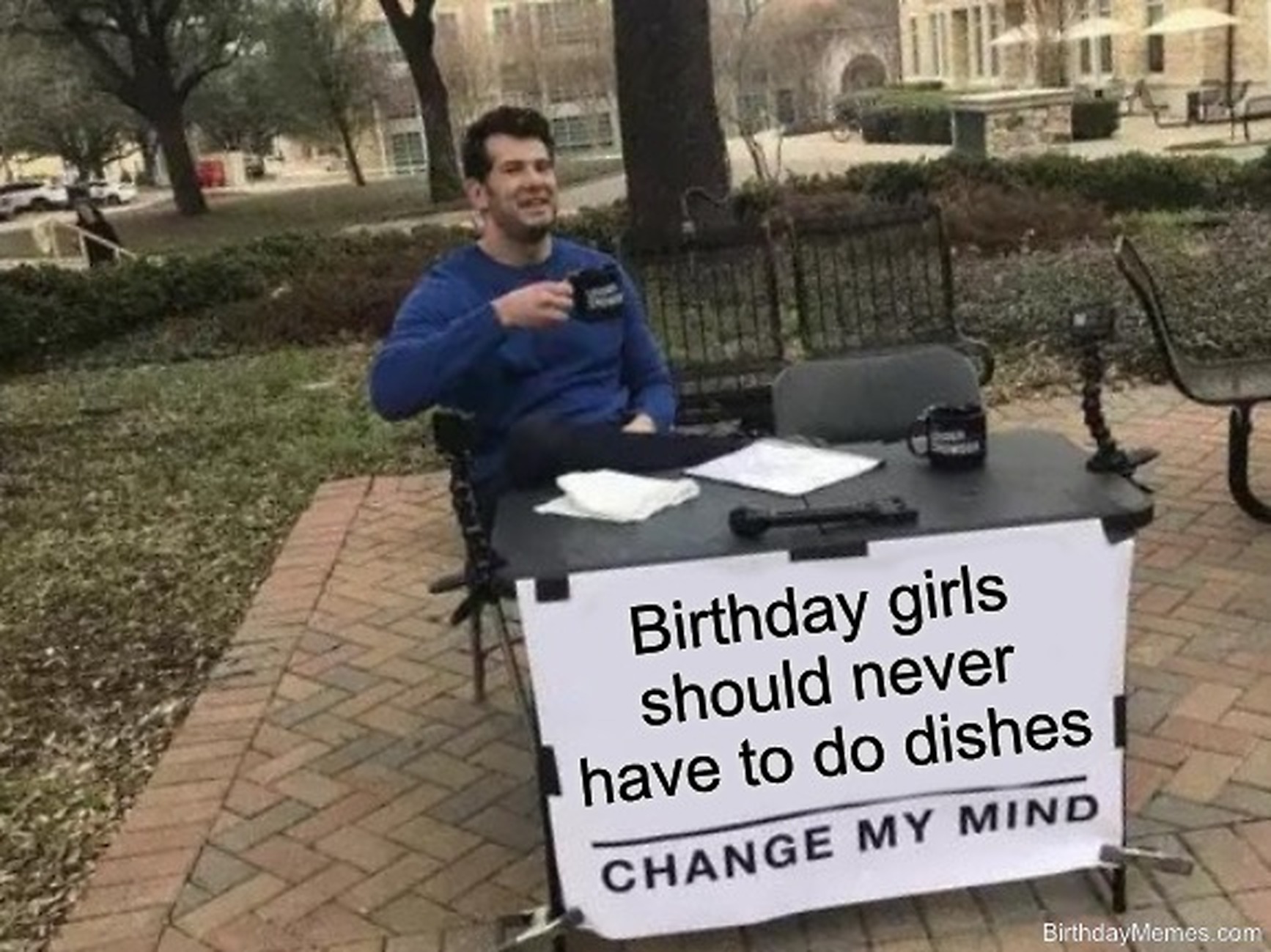 Man sits at a table with a sign reading 'Birthday girls should never have to do dishes. Change my mind.'