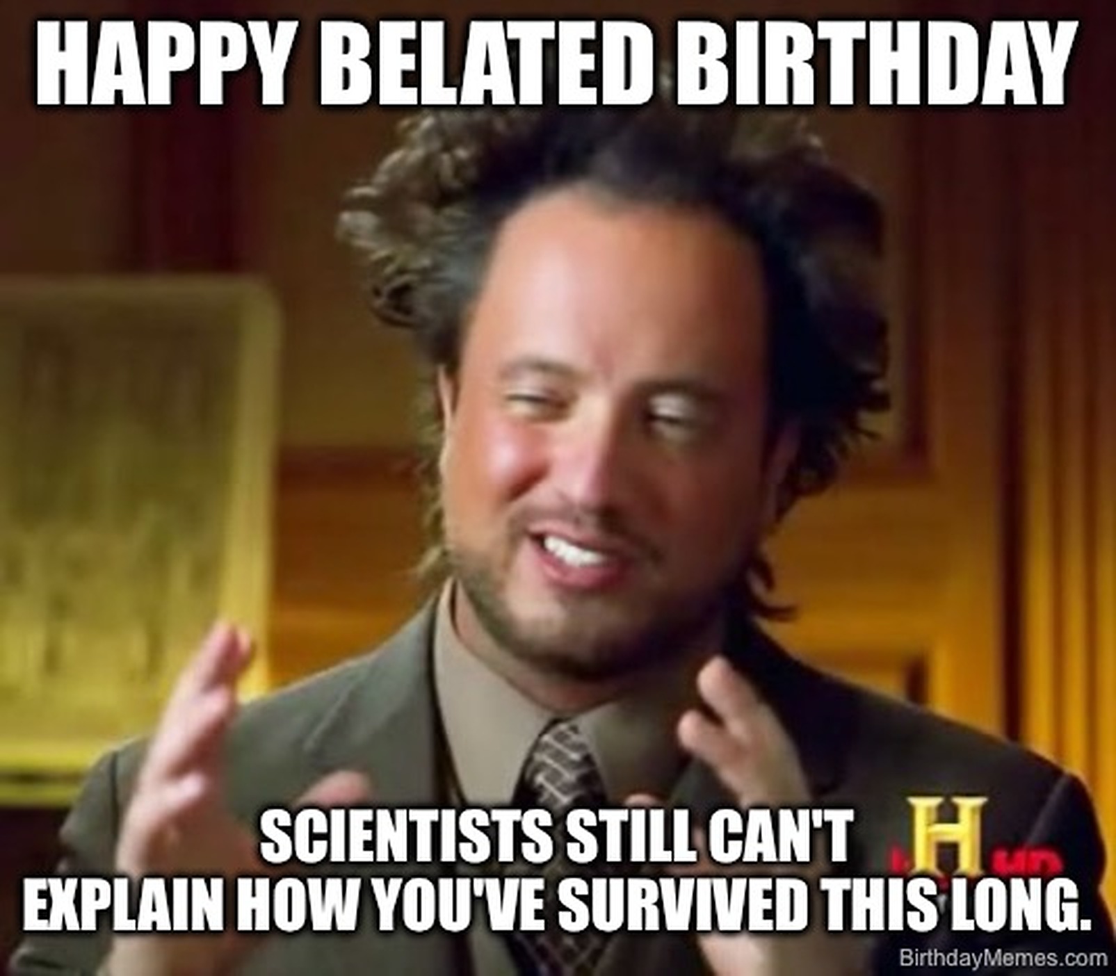 A man with wild hair gestures seriously, with text: Happy belated birthday. Scientists still can't explain how you've survived this long.
